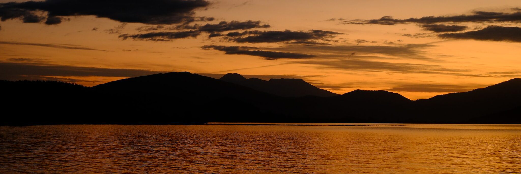 Atardecer sobre un lago entre montañas en Nueva Zelanda