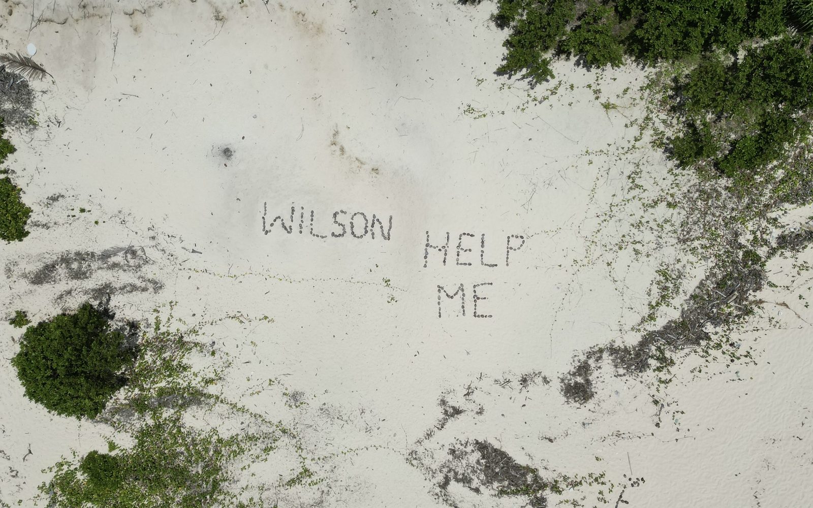 "Wilson" y "Help me" escritos en la arena de Monuriki, la isla de Náufrago