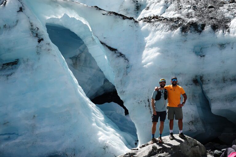 Dos viajeros en una cueva de hielo de un glaciar